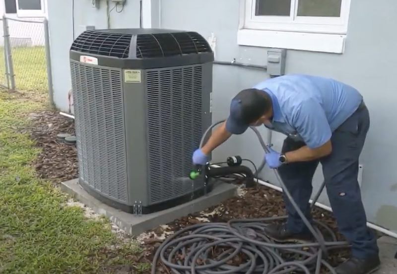 man cleaning the condenser coil